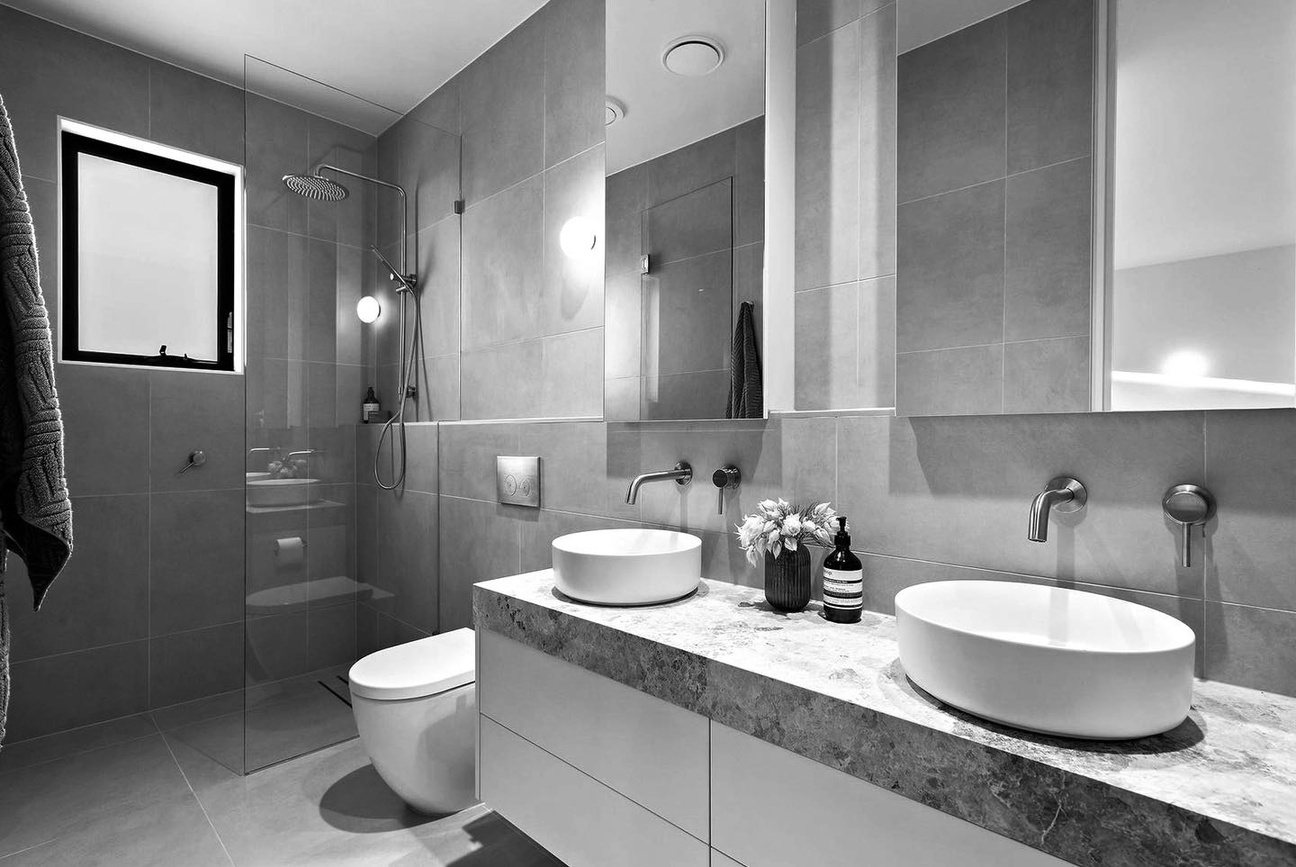 Ensuite with a double stone-topped vanity, twin vessel basins and a mirrored cabinet above.