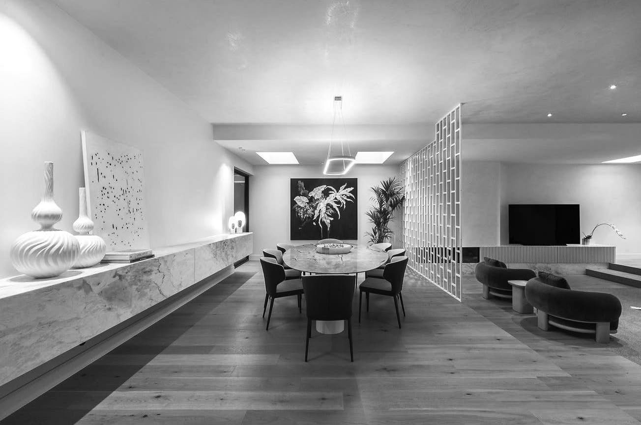 Open plan living and dining in the Brighton home, anchored by a full length stone island bench.